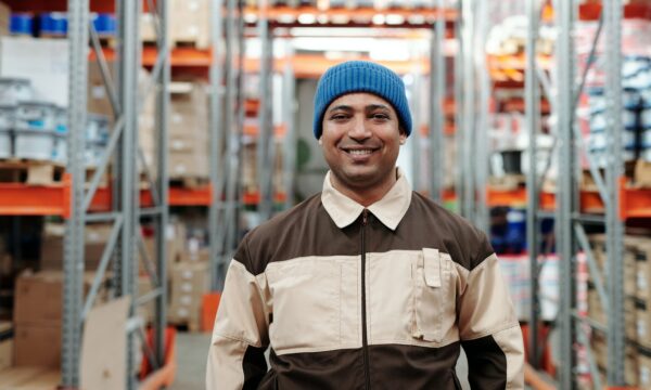 man smiling behind a warehouse background